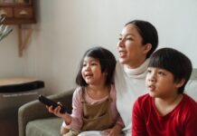 The Super Mario Bros. Movie A young boy and girl viewing streaming options for new movies on the couch with their mother