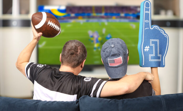 Fans of american football. Father and son watching TV. A father and son watching the Super Bowl on TV at home.